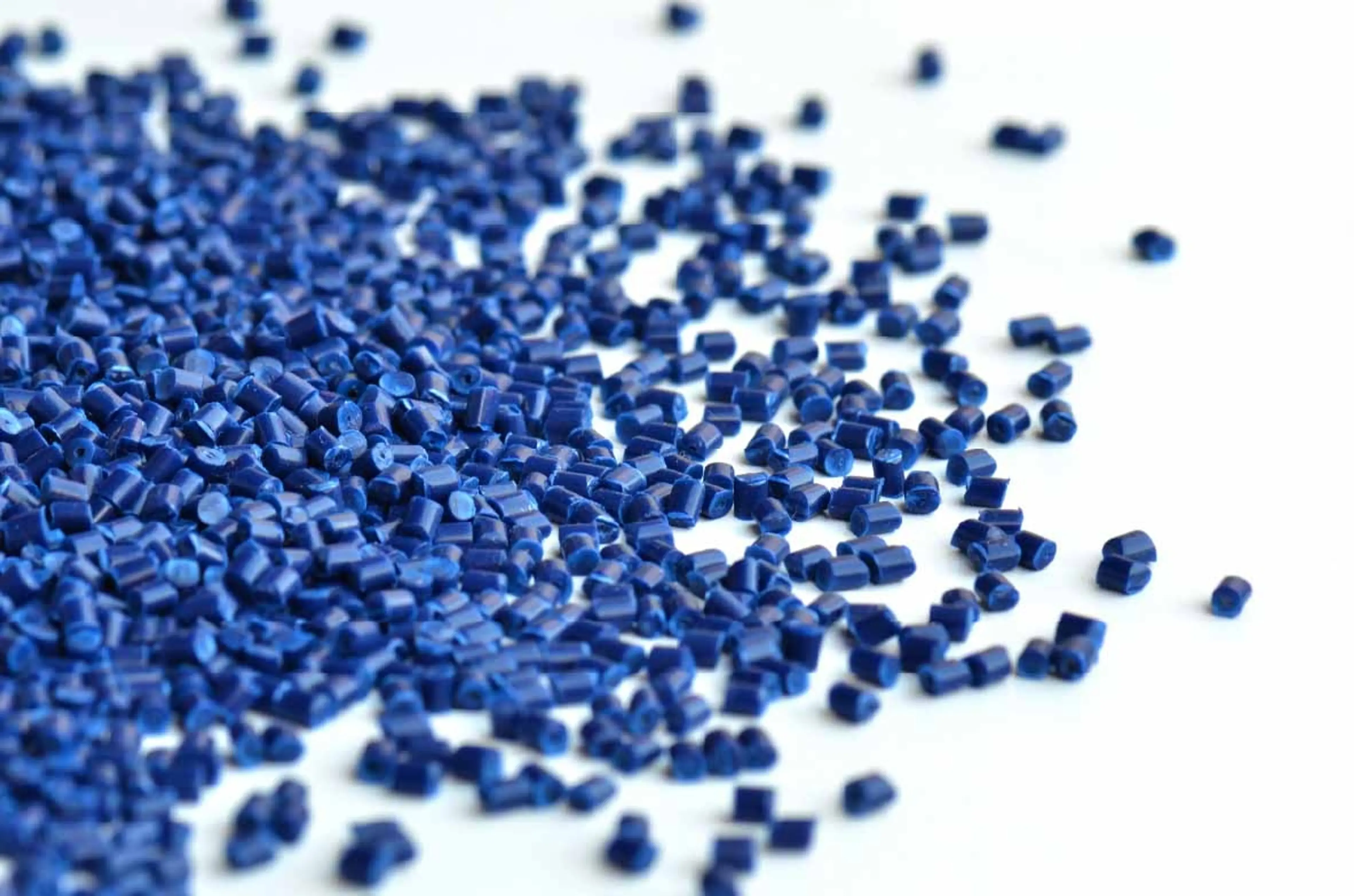 Blue plastic pellets on white background