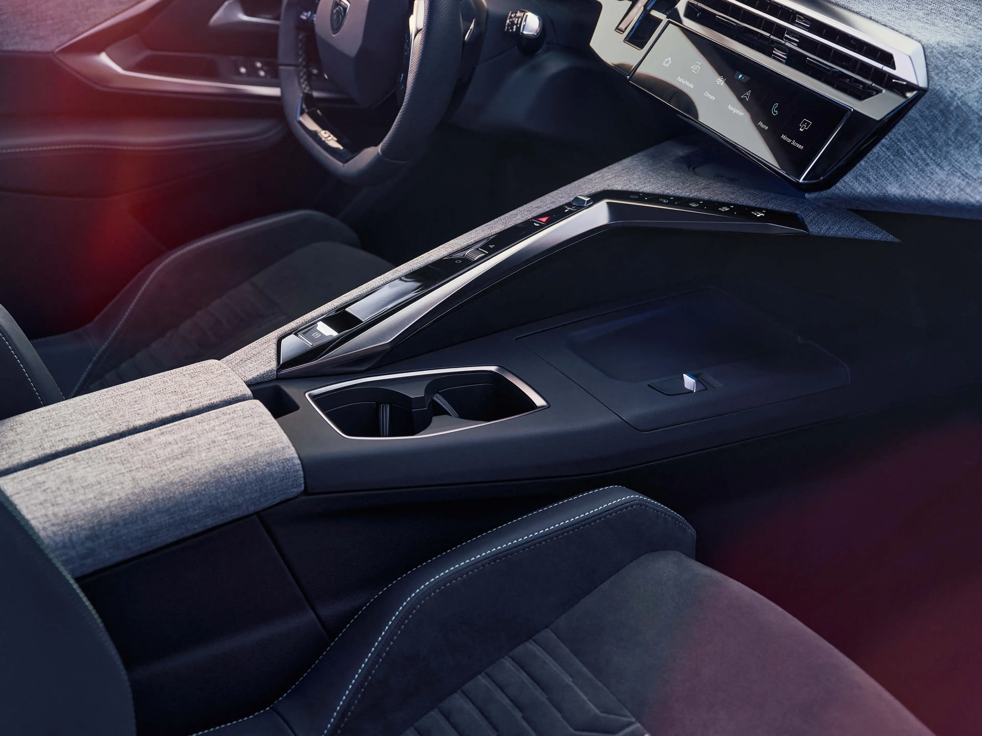 The image shows the modern interior of a car with a sleek dashboard, digital display, and a center console featuring cupholders and armrest in a sophisticated design.