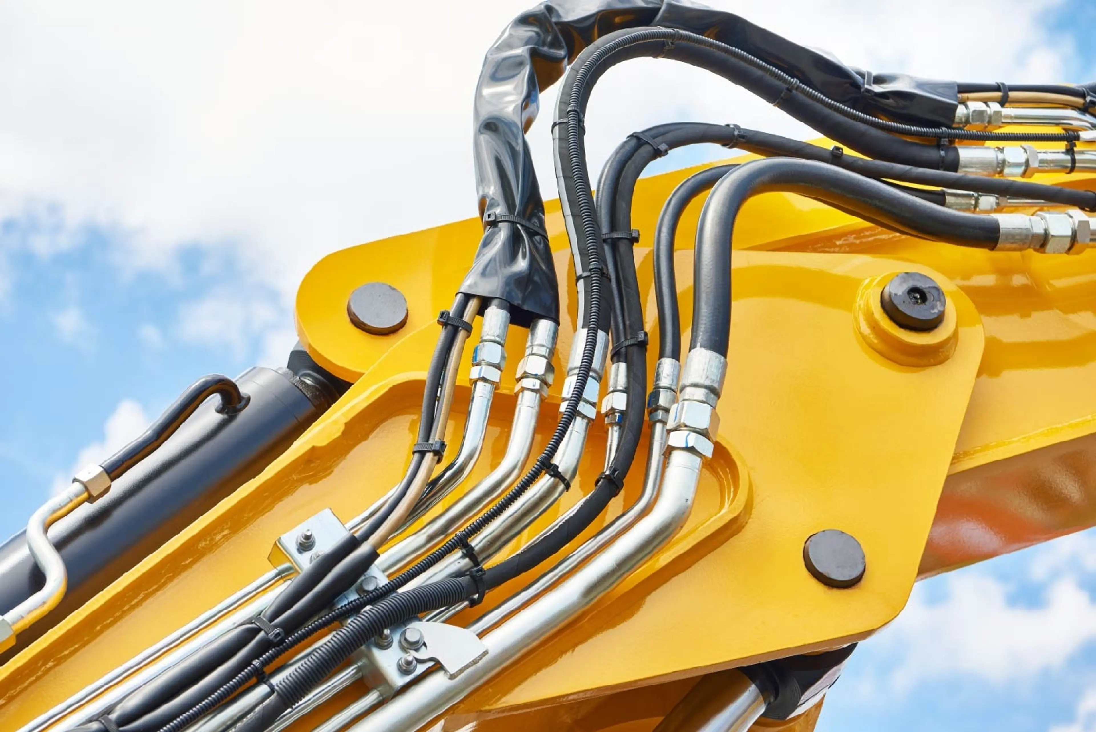 Hoses of modern hydraulic system on yellow machine