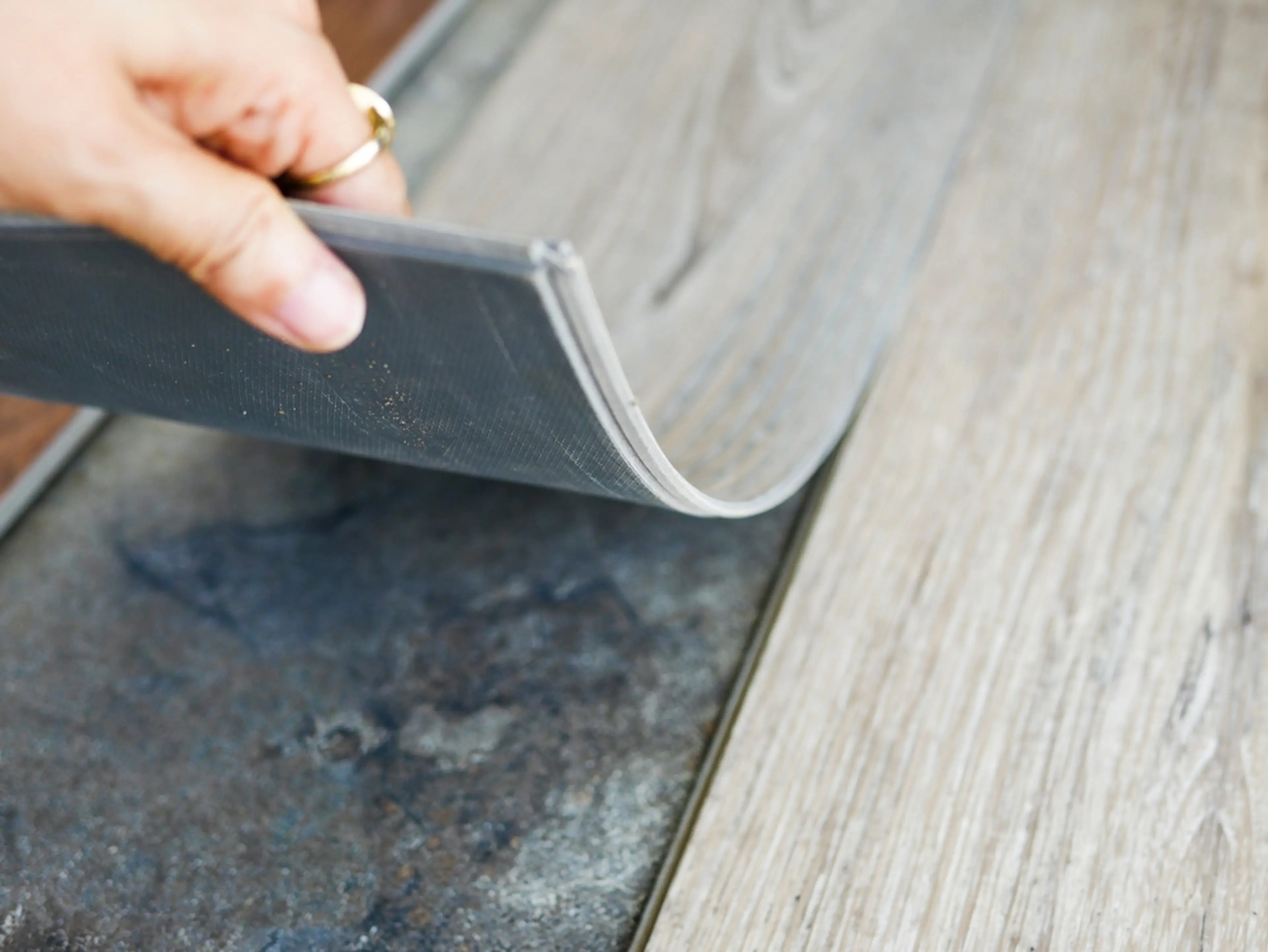 Image of person lifting a panel of PVC flooring