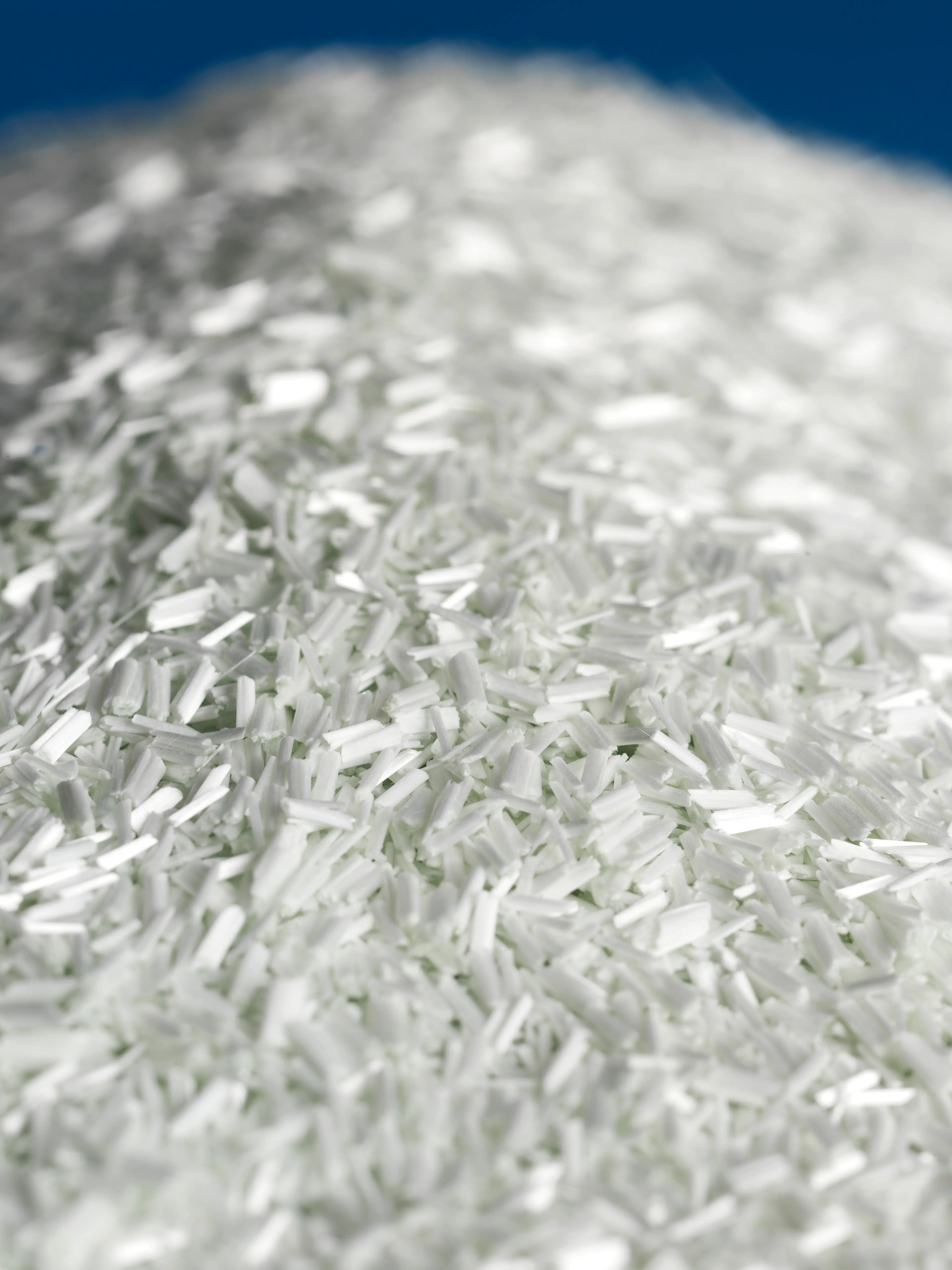 Heap of white plastic fibre on blue background