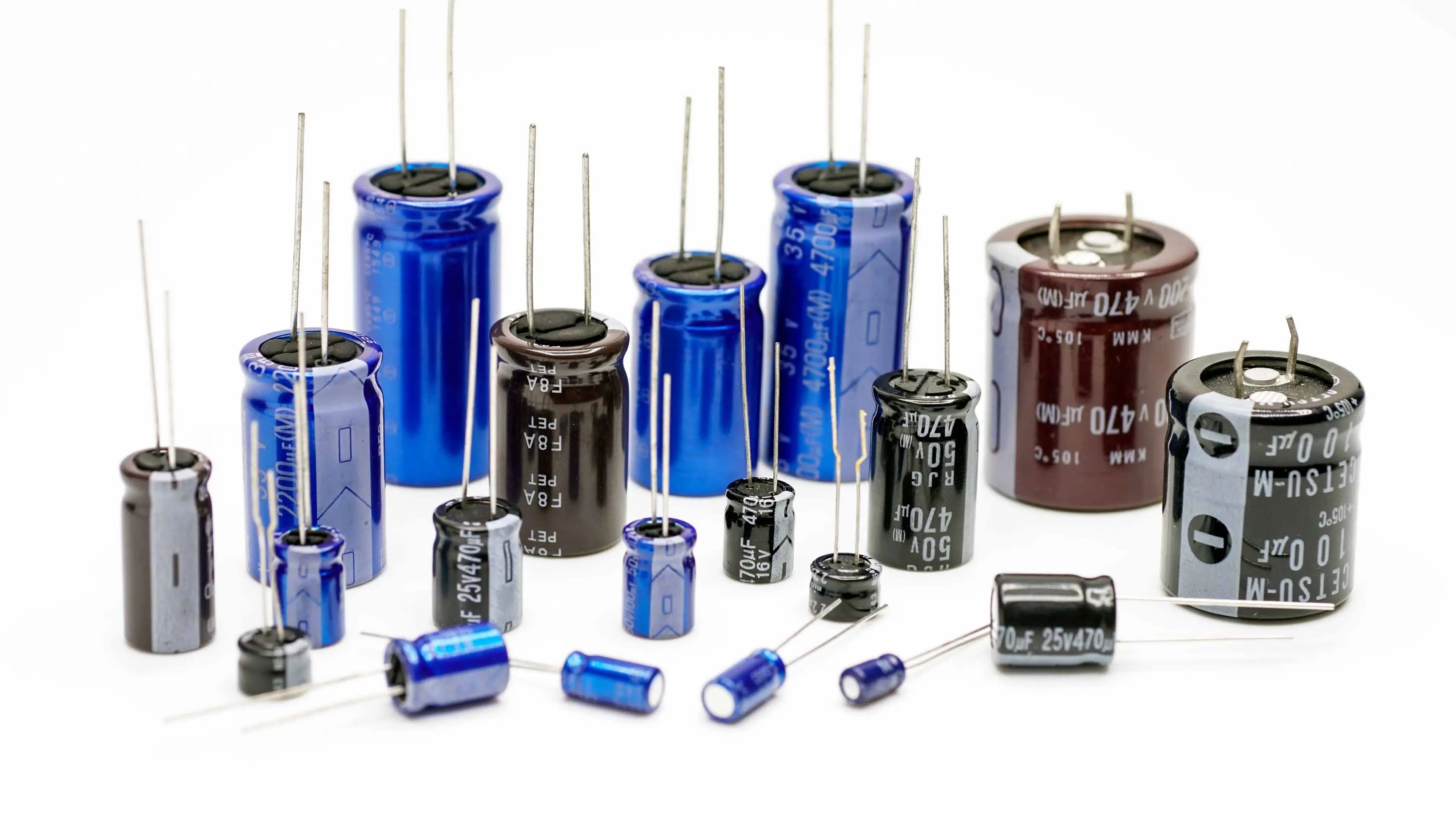 Electrolytic capacitors, many colors and sizes, white background,