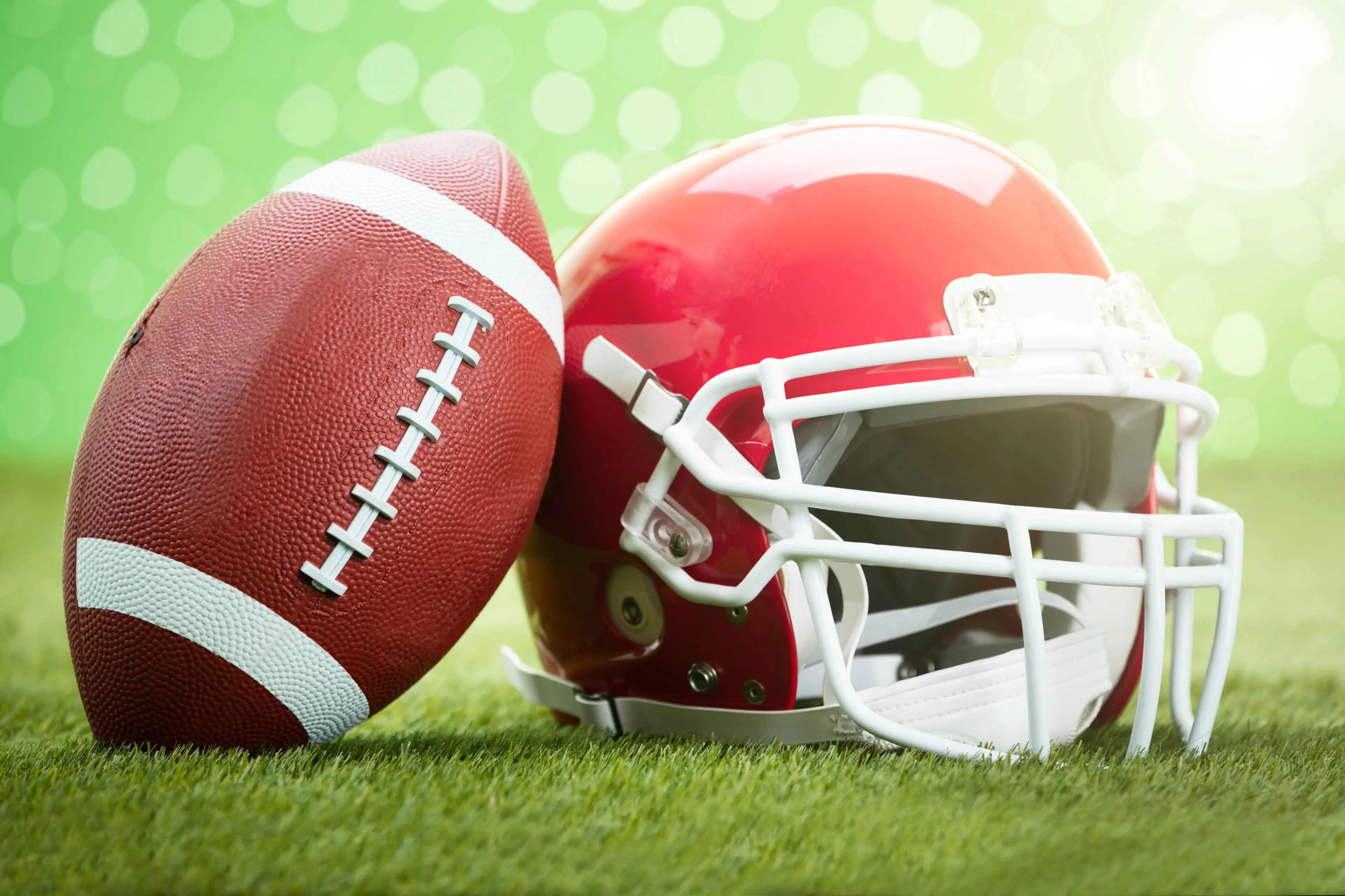 football helmet and ball on grass pitch