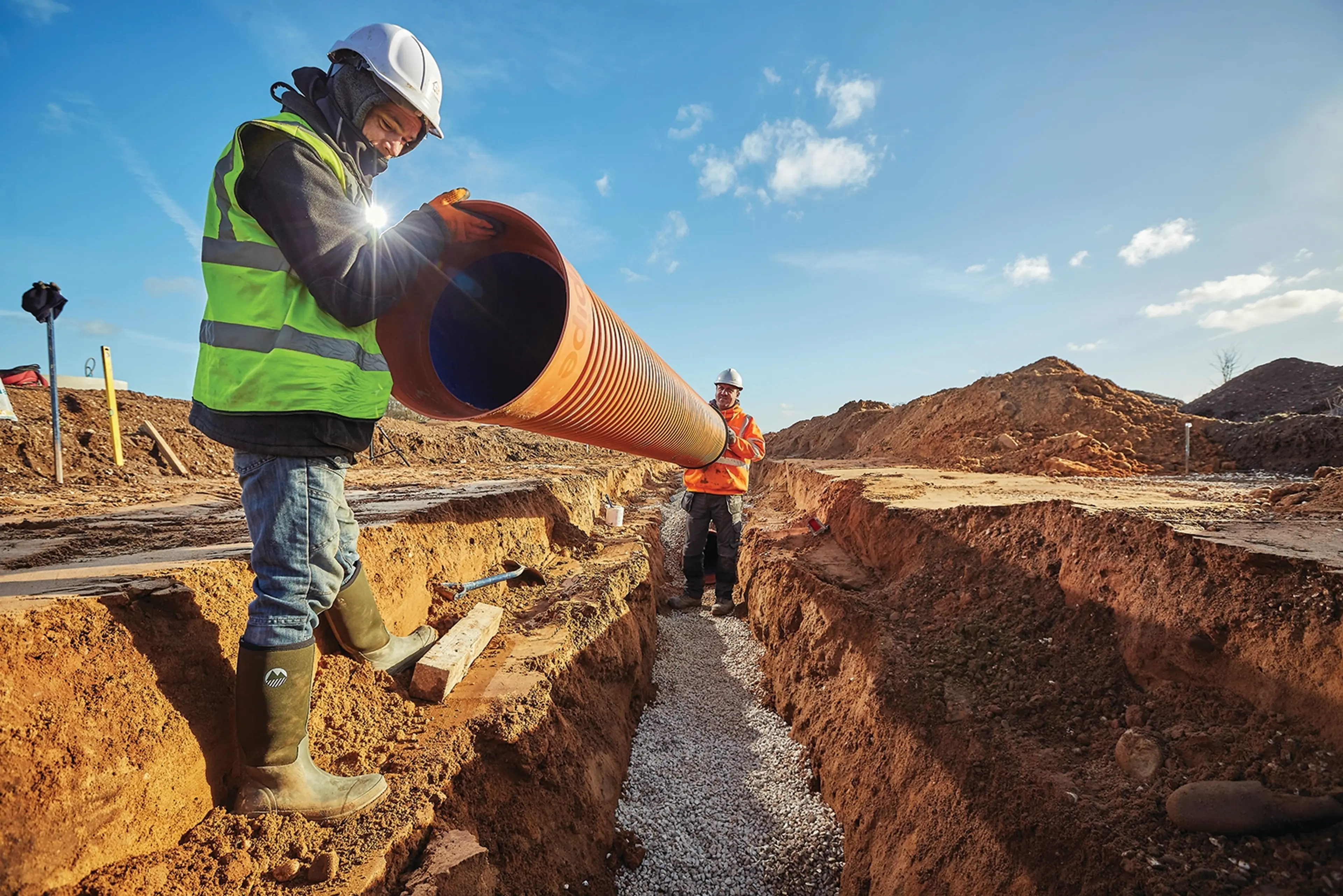 Man holding large diameter underground pipe